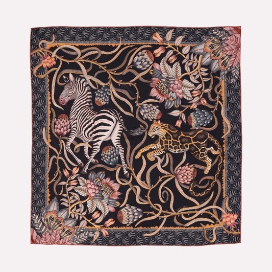 A silk scarf with a dark, dramatic background, featuring zebras, florals, and intricate vine patterns in gold and blush hues, evoking an African twilight.