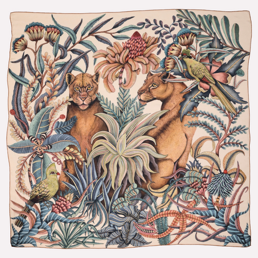 A square scarf featuring an intricate African wildlife scene, with two lionesses surrounded by lush foliage and a turaco bird, blending earthy tones with rich blues and greens.