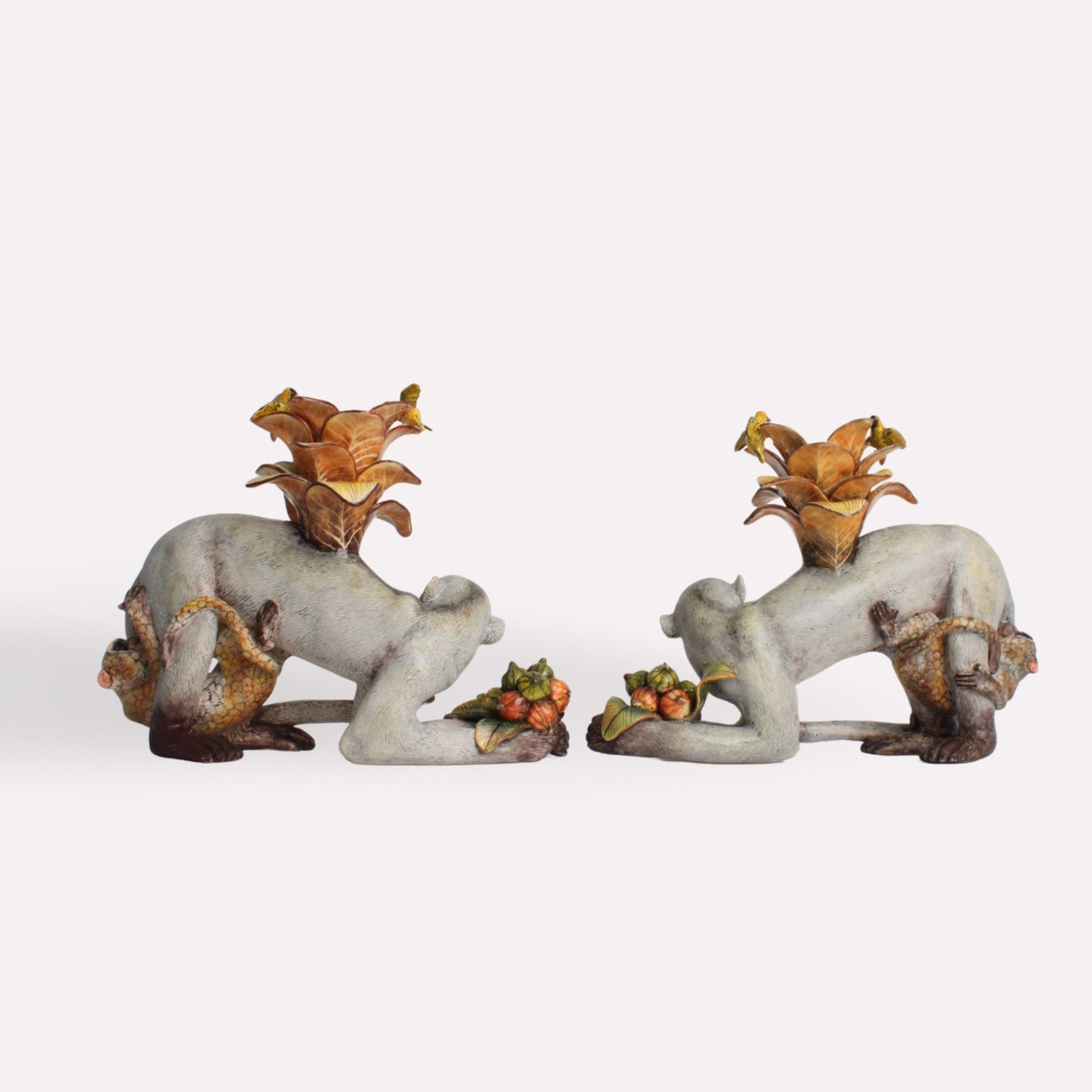 A side-angle perspective of the ceramic monkey candle holders, highlighting the intricate hand-painted details, expressive faces, and realistic fur texture.