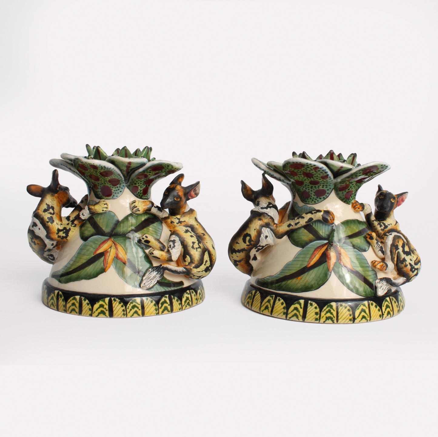 A pair of intricately designed ceramic wild dog candle holders, featuring hand-painted African wild dog motifs in earthy tones with a decorative base.