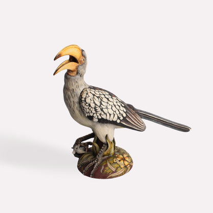 A side-angle view of the ceramic hornbill sculpture, showcasing the intricate feather detailing, curved beak, and realistic stance.