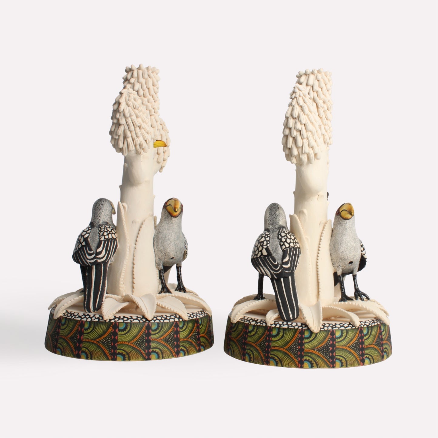 A back perspective of the candle holders, showing the full sculptural depth of the tree branches and the hornbills resting on the base.