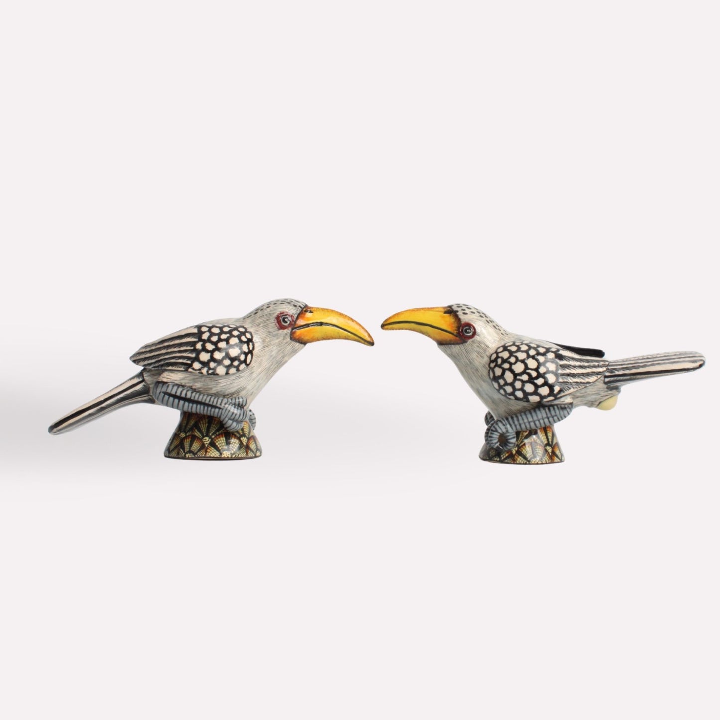 A side perspective of the ceramic shakers, showcasing their sculpted wings, speckled patterns, and elegant craftsmanship.