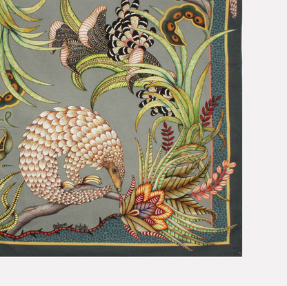 A neatly folded tea towel showcasing a mix of pangolin and plant motifs, elegantly designed with earthy tones.