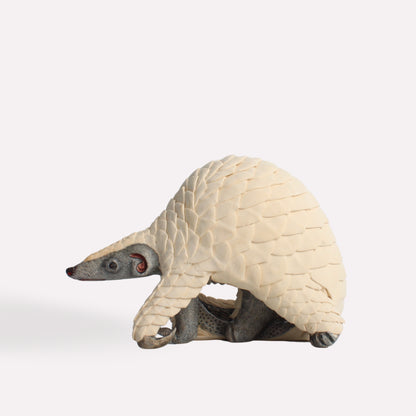 A three-quarter perspective of the sculpture, capturing the natural curvature of the pangolin’s body and the lifelike detailing of its protective scales.