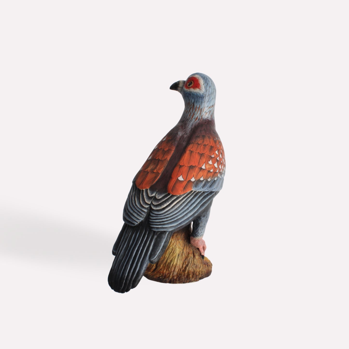 An alternate side view of the pigeon sculpture, focusing on its curved tail, black-tipped feathers, and the fine brushwork of the artist.