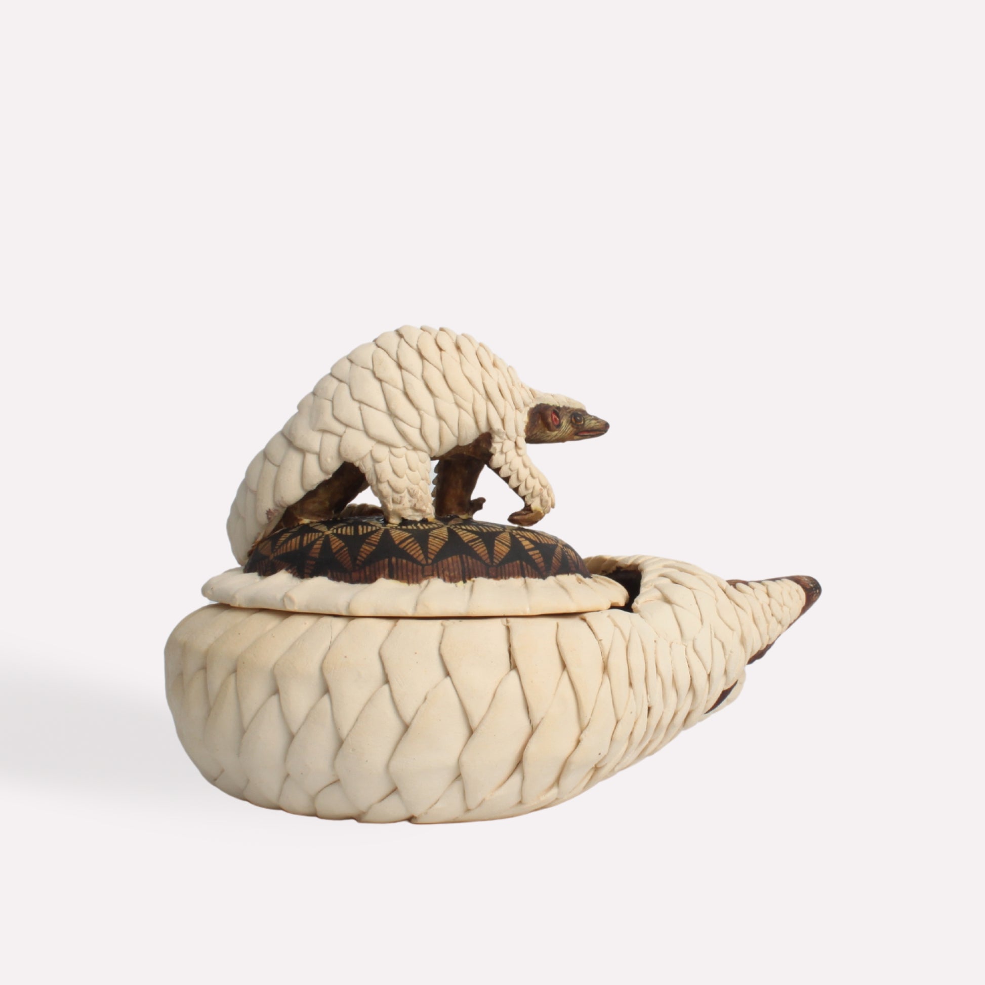 A side-angle image showcasing the trinket box’s round, coiled pangolin design. The lid seamlessly blends with the base, creating a sculptural effect that mimics the natural curl of a real pangolin.